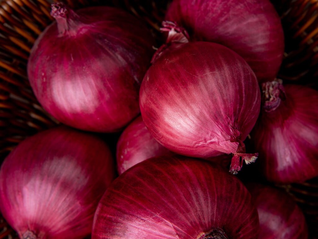 close up view of basket of red onions